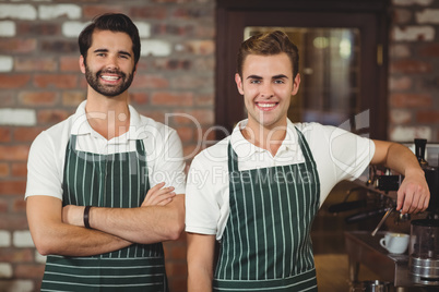 Two smiling baristas looking at the camera