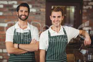 Two smiling baristas looking at the camera