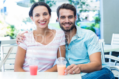 Happy couple drinking milkshakes together