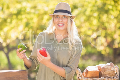 Smiling blonde holding red and green peppers