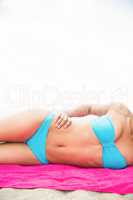 Slim woman sunbathing on towel