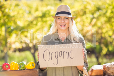 Smiling blonde holding an organic signboard