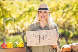 Smiling blonde holding an organic signboard