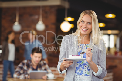 Smiling blonde woman eating cake