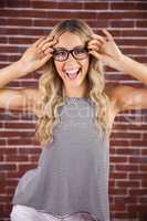 Gorgeous smiling blonde hipster posing with glasses