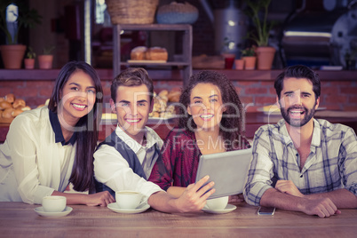 Smiling friends holding a digital tablet