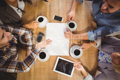 Smiling friends chatting and drinking coffee