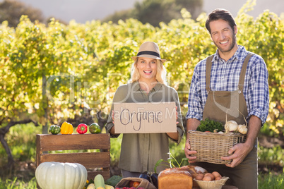 Farmer couple holding a basket and organic sign