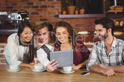 Smiling friends looking at digital tablet