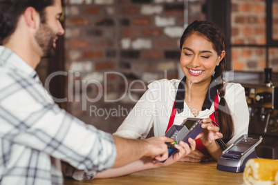 Smiling customer typing on the pin terminal