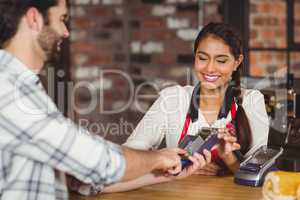 Smiling customer typing on the pin terminal