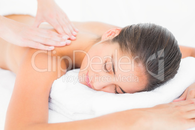 Attractive woman receiving shoulder massage at spa center