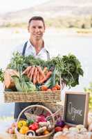 Smiling farmer holding a basket of vegetables