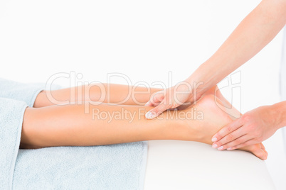 Woman receiving leg massage at spa center