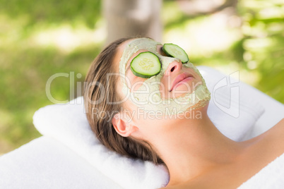 Attractive woman having cucumber on her face