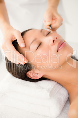 Woman placing fake eyelash on a patient