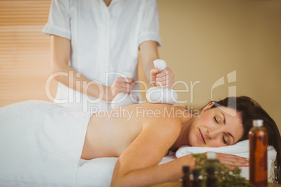 Young woman getting herbal compress massage