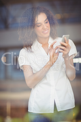 Smiling woman sending a text