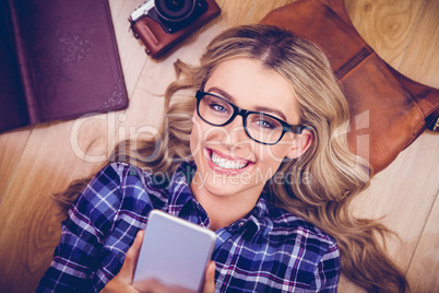 Gorgeous smiling blonde hipster using smartphone