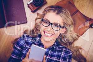 Gorgeous smiling blonde hipster using smartphone