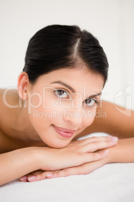 Pretty brunette enjoying a massage smiling at camera