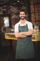 Smiling barista with arms crossed