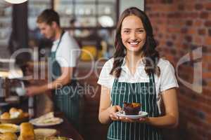 Pretty waitress holding a plate with muffin