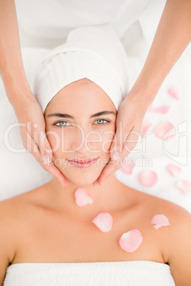 Attractive woman receiving facial massage at spa center