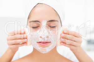 Hands cleaning woman face with sponge
