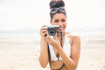 Pretty hipster in bikini taking picture