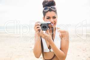 Pretty hipster in bikini taking picture