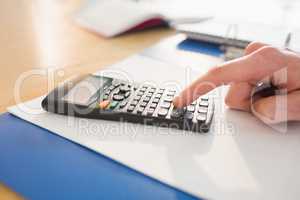 Businessman hands typing on calculator