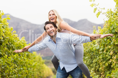 Young happy man carrying happy woman on his back