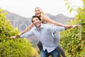 Young happy man carrying happy woman on his back