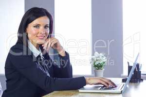 Businesswoman working on laptop at her desk