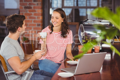 Smiling friends drinking coffee and chatting