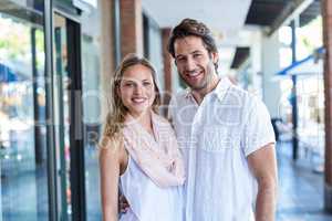 Smiling man putting arm around his girlfriend