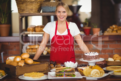 Pretty waitress bended over a food table