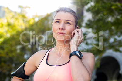 A beautiful athlete putting her headphones