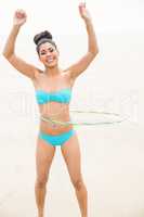 Fit woman hula hooping in bikini