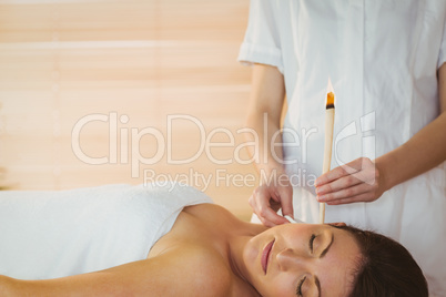 Young woman getting an ear candling treatment