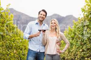 Young happy couple holding a glass of wine and looking in the di