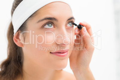 Hand applying mascara to beautiful woman