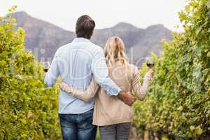 Rear view of a young happy couple holding glasses of wine