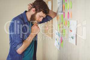 Bearded hipster looking at brainstorm wall