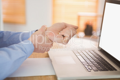 Businessman clutching his painful wrist