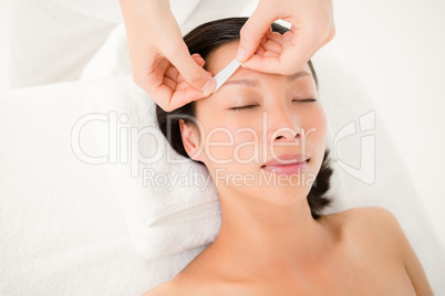 Hand waxing beautiful womans eyebrow