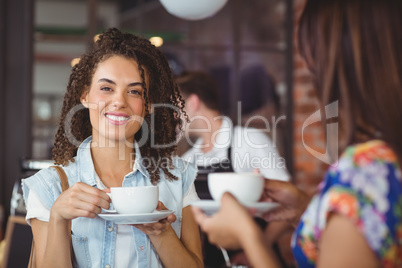 Smiling pretty customer holding cup of coffee