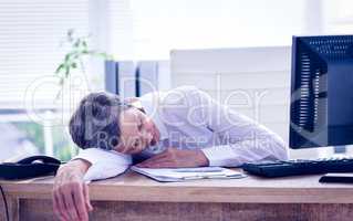 Tired businesswoman sleeping at her desk