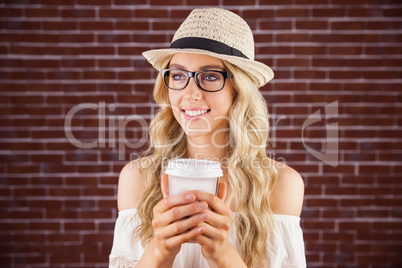 Gorgeous smiling blonde hipster holding take-away cup